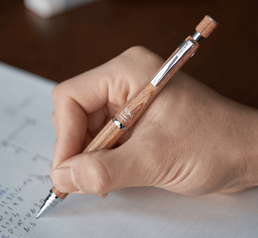 Pilot S30 ahşap gövdeli kalem elde tutulurken çizgili deftere matematik notları yazılıyor