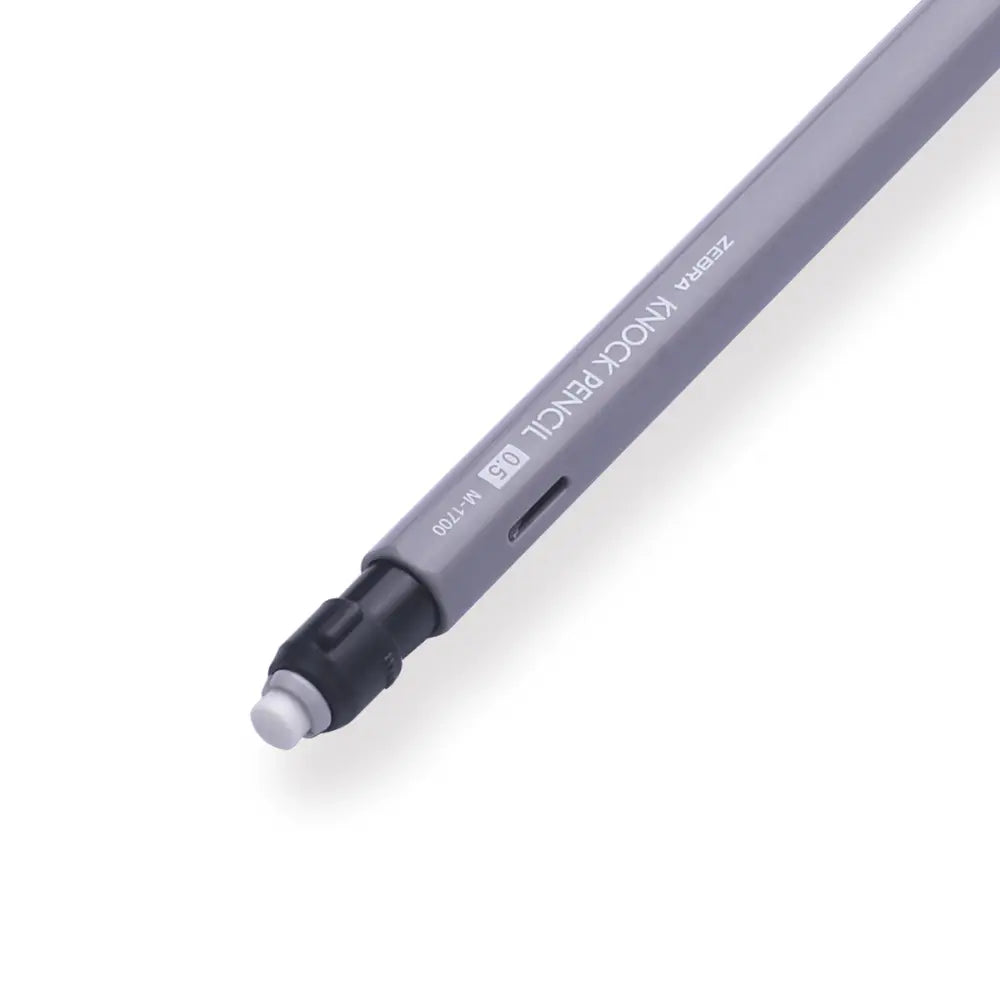 Zebra M-1700 gri kalemin arka ucu; siyah tıklama başlığı altından çıkan beyaz silgi görünür