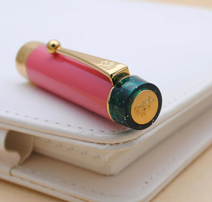 Jinhao 100 kalemin kapak ucundaki yeşil reçine ve altın madalyon detayı
