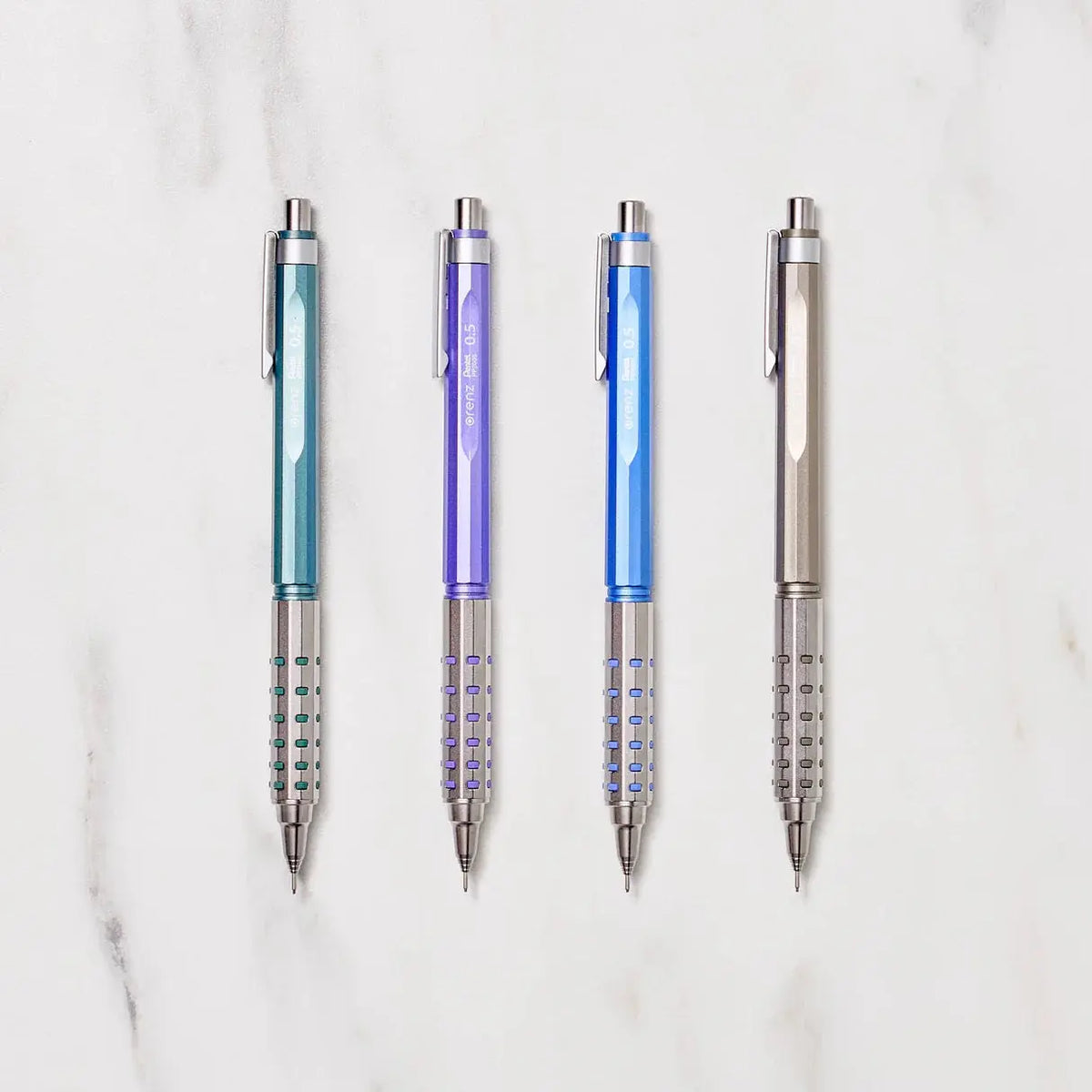 Pentel Orenz AT Limited versatil kalem, mermer zeminde yeşil, mor, mavi ve bronz dört gövde, 0.5 mm