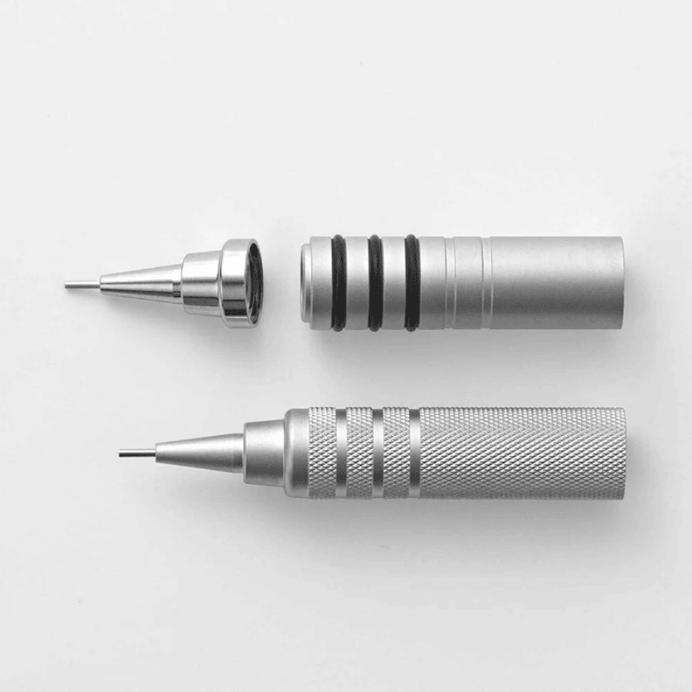 Zebra Tect 2way gümüş kalemin sökülmüş hali; koni uç, iç gövde ve tırtıklı kavrama ayrı ayrı