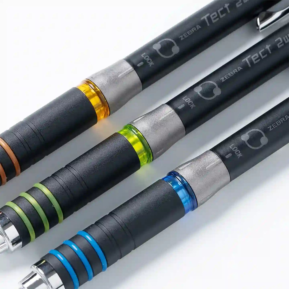 Zebra Tect 2way kalemlerin turuncu, yeşil ve mavi halkalı kavramaları ile LOCK yazısı yakın çekimde