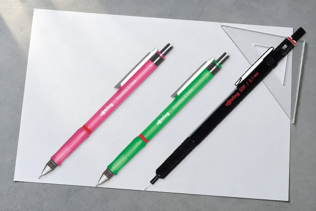 Pembe ve yeşil Rotring Visuclick ile siyah Rotring 500 versatil kalem, beyaz kâğıt ve gönye üzerinde