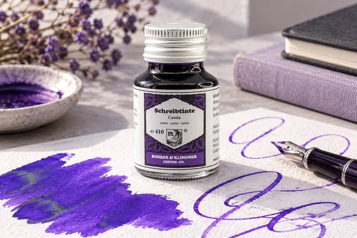 Rohrer & Klingner Cassia Şişe Mürekkep 50 ml; renk tonuyla uyumlu kâğıtlar ve yazı araçlarıyla masa düzeni