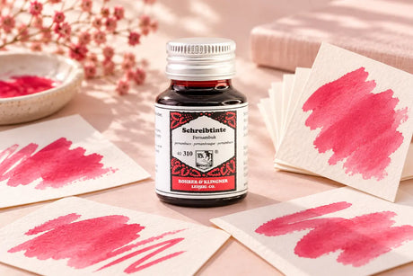 Rohrer & Klingner Fernambuk Şişe Mürekkep 50 ml; renk tonuyla uyumlu kâğıtlar ve yazı araçlarıyla masa düzeni
