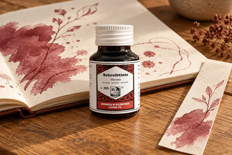 Rohrer & Klingner Morinda Şişe Mürekkep 50 ml; renk tonuyla uyumlu kâğıtlar ve yazı araçlarıyla masa düzeni
