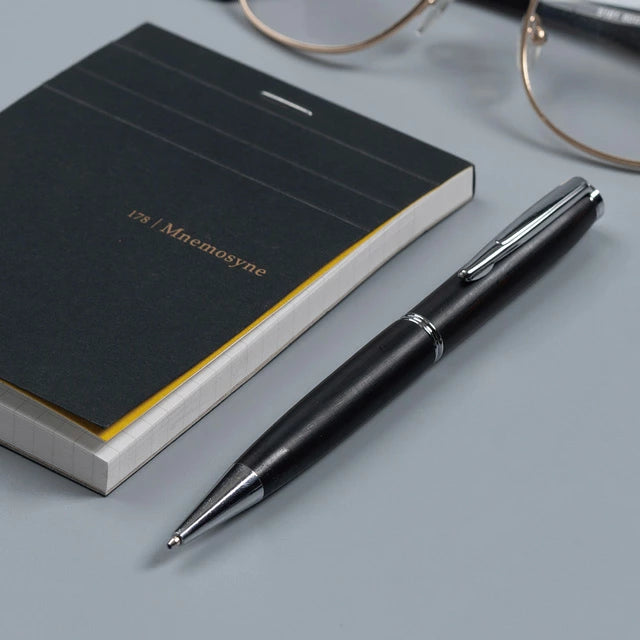 Gentlewood Studio siyah ahşap tükenmez kalem, Mnemosyne defter ve gözlükle masa üstü kurgusunda