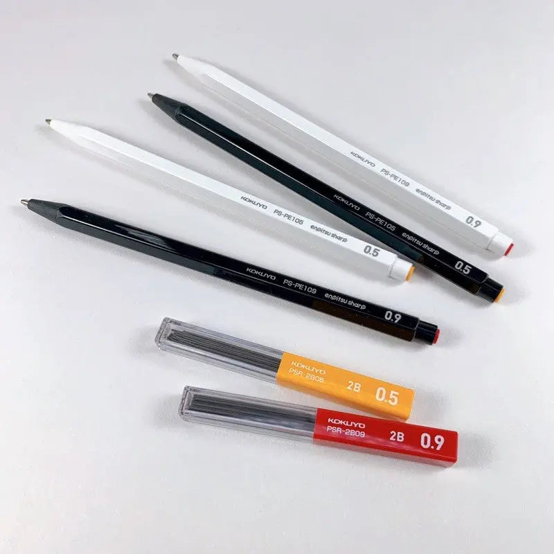 Kokuyo Enpitsu Sharp beyaz ve siyah kalemler yan yana, yanında 2B 0.5 ve 0.9 uç tüpleri