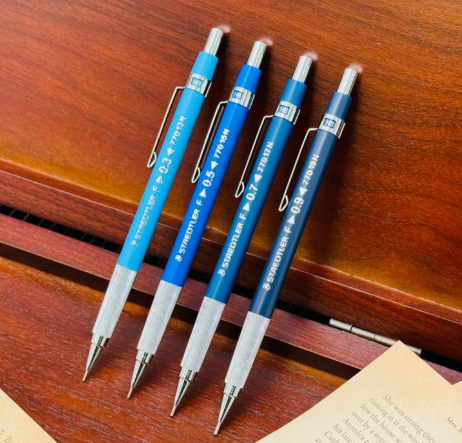 Staedtler 770 kalemin dört uç kalınlığı ahşap masada yan yana, 0.3, 0.5, 0.7 ve 0.9 mm