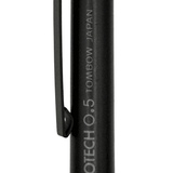 Tombow Monotech 0.5 gövde gravdürü ve ince siyah klips, mat yüzeyde yakın çekim