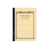Apica CD-11 A5 defterin sarı kapağı, süslü çerçeveli Note Book baskısı ve siyah bez sırt